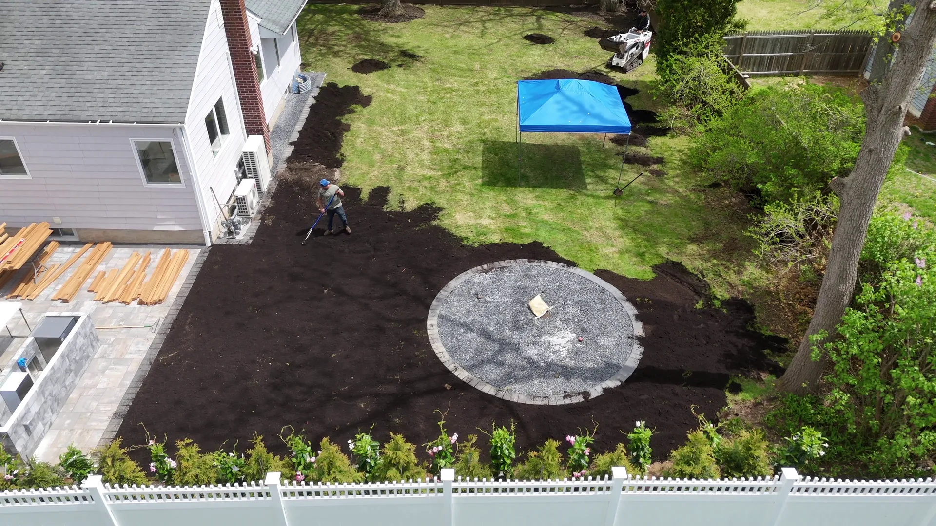 Aerial of a tidy backyard with a new shed, fresh lawn, and clean planting beds.